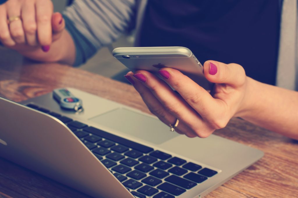 Woman booking a hostel on her mobile phone.