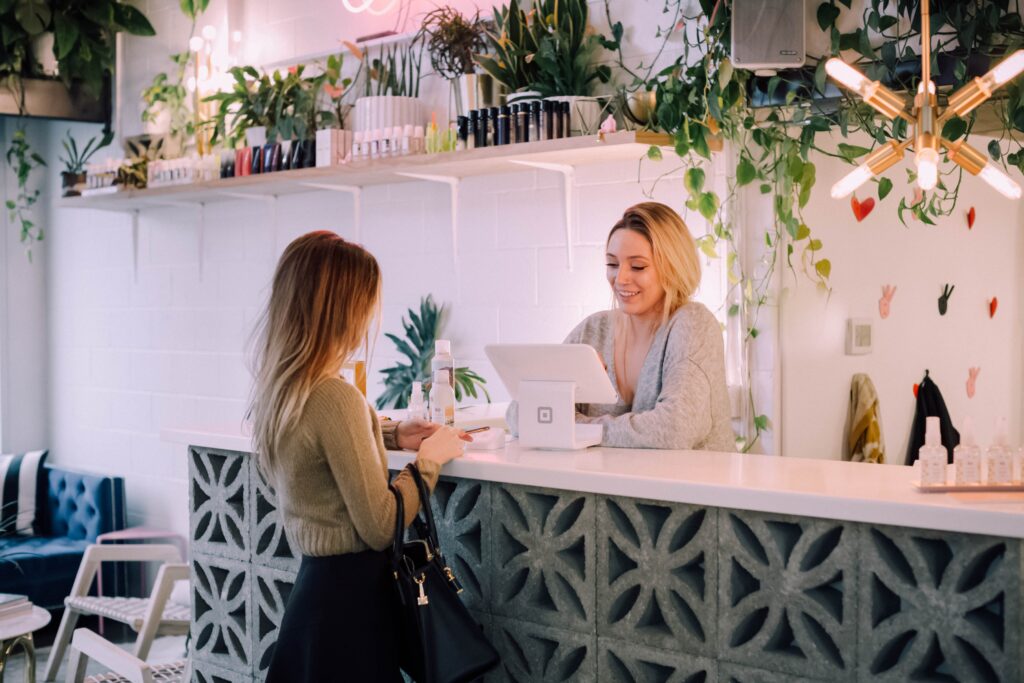 Woman making check-in at the front desk to a guest