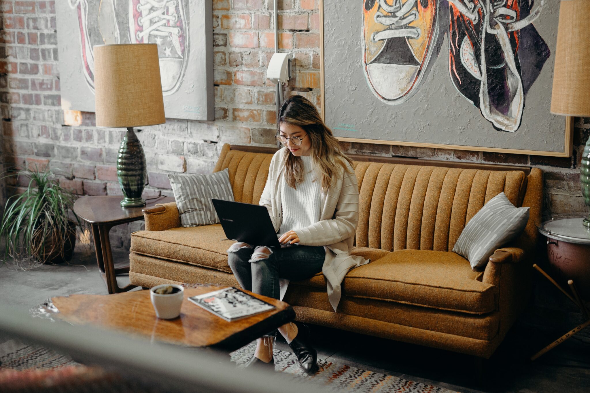 Woman using laptop while sitting on sofa